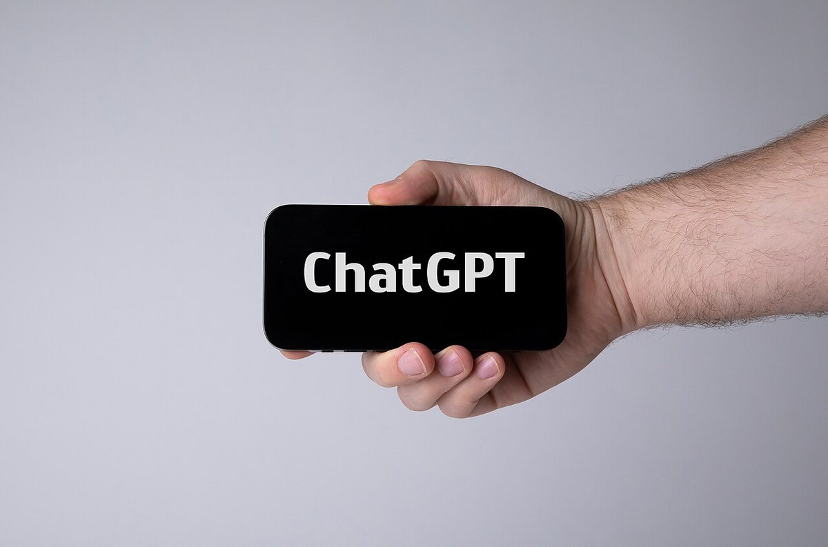 Mano sosteniendo un celular con la aplicación de ChatGPT abierta