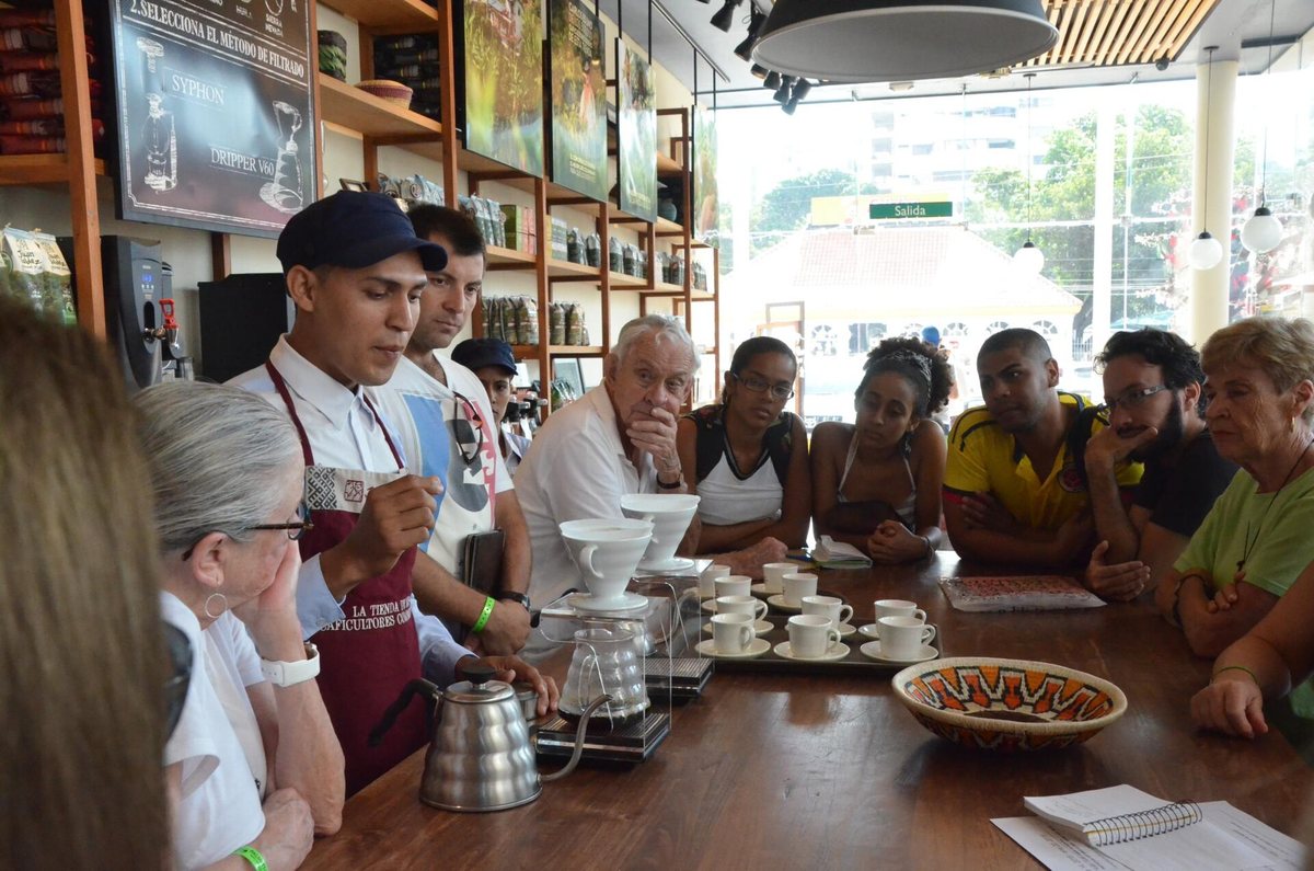 Barista explicando el método de café filtrado a un grupo de clientes en una tienda de café en Cartagena