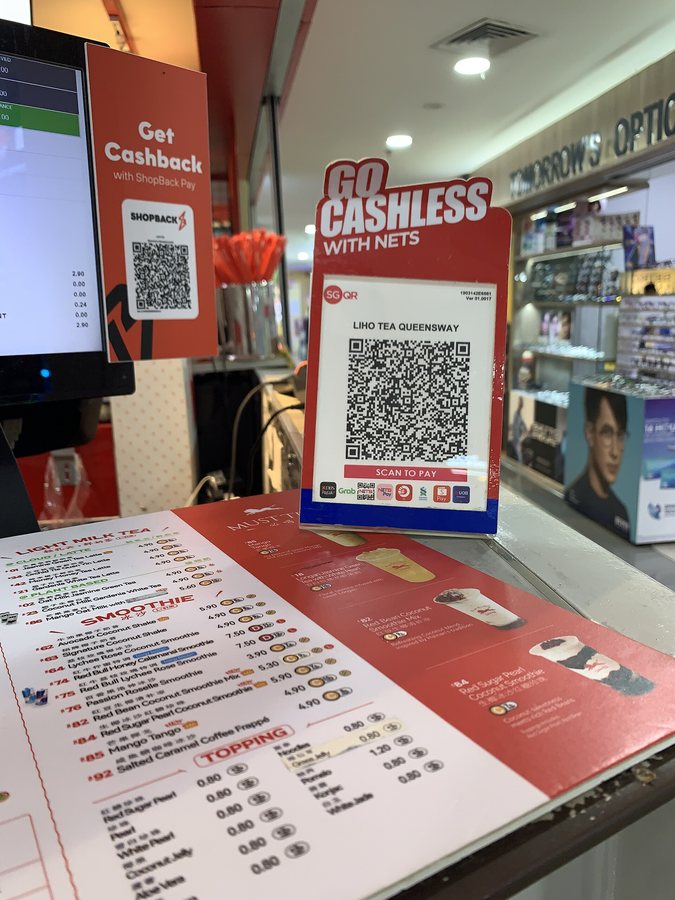 Código QR de pago exhibido en el mostrador de una tienda de bebidas