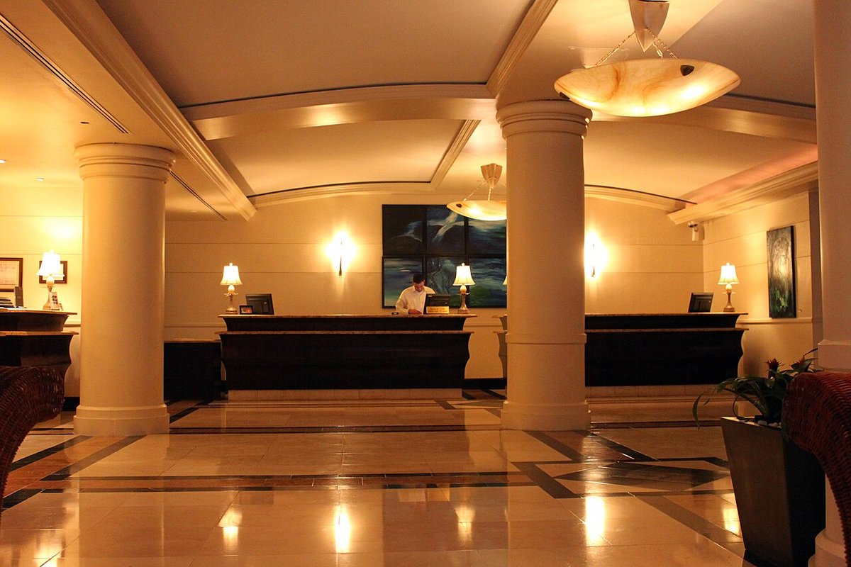 Recepción de un hotel con mostrador y lobby iluminado